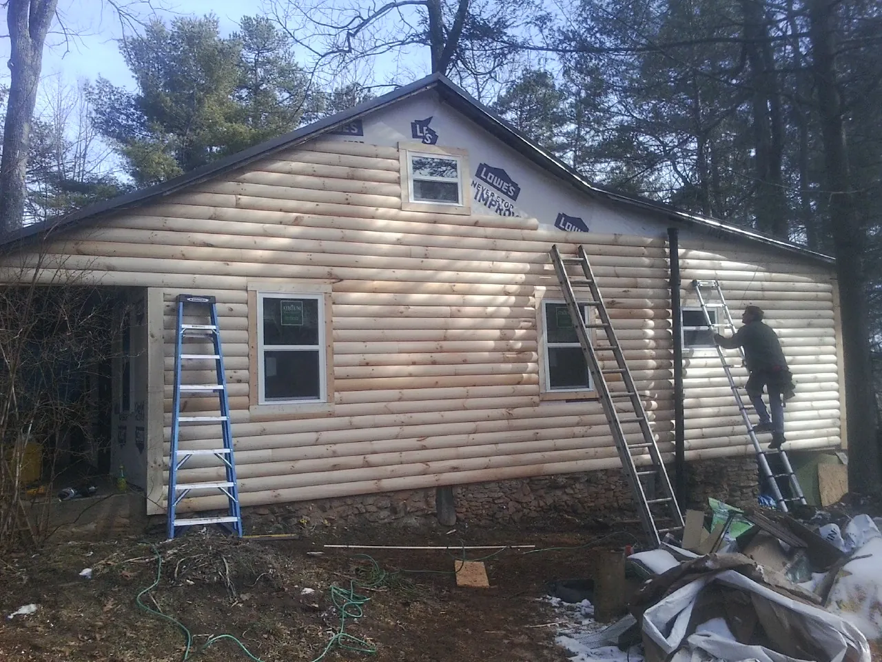 Ladders set against fresh log siding during an exterior remodel in Tobyhanna