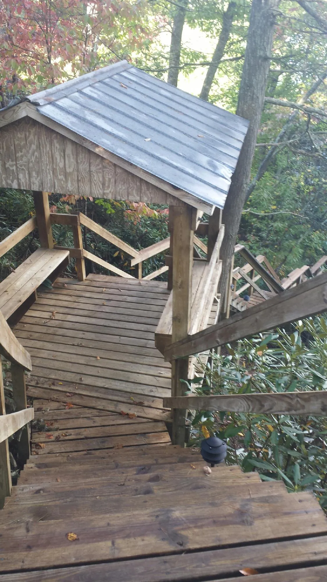 Metal roofed shelter over wooden steps on a wooded walkway — Skylight Repair & Installation work by our crew in Tobyhanna