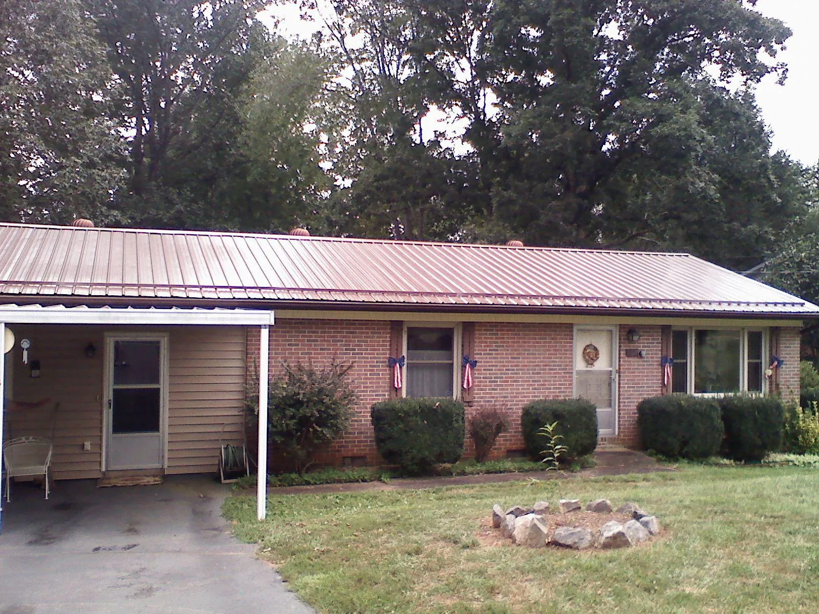 Bronze metal roof and carport on a brick ranch home — Roof Repair work by our crew in Tobyhanna